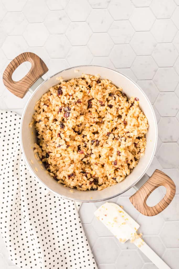 Cranberry orange crispy treat mixture fully combined in a saucepan before being pressed into the pan.