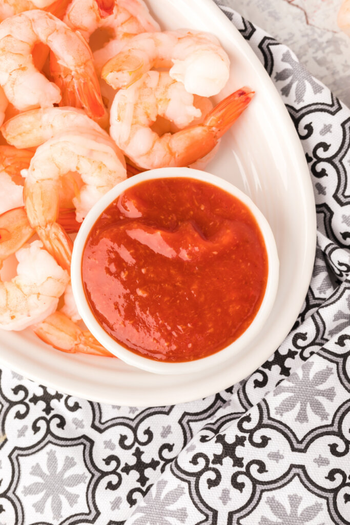 shrimp cocktail sauce and chilled shrimp on white plate