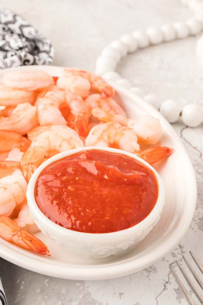 shrimp and shrimp cocktail sauce on white serving platter