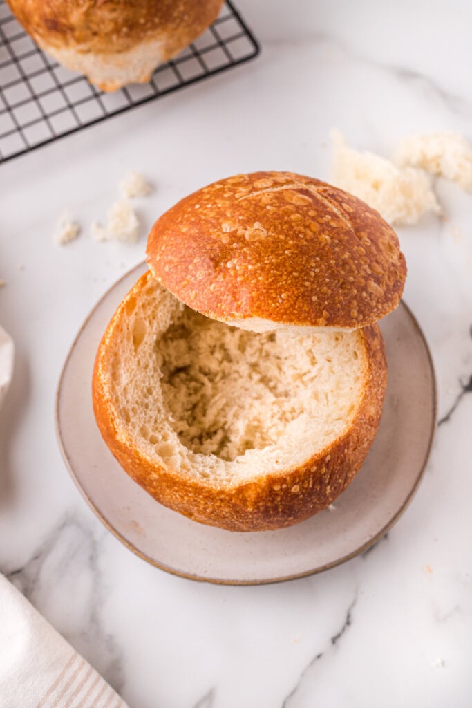 bread bowl with top cut off and hollowed out on plate