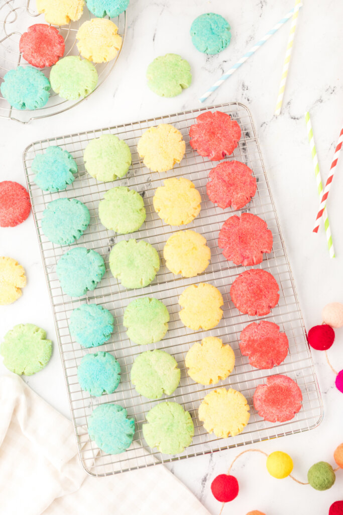 four different colors of jello cookies on cooling rack