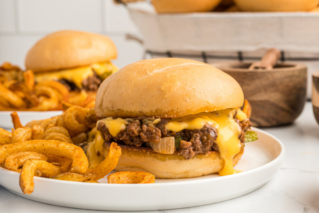 philly cheesesteak sloppy joe on plate with curly fries