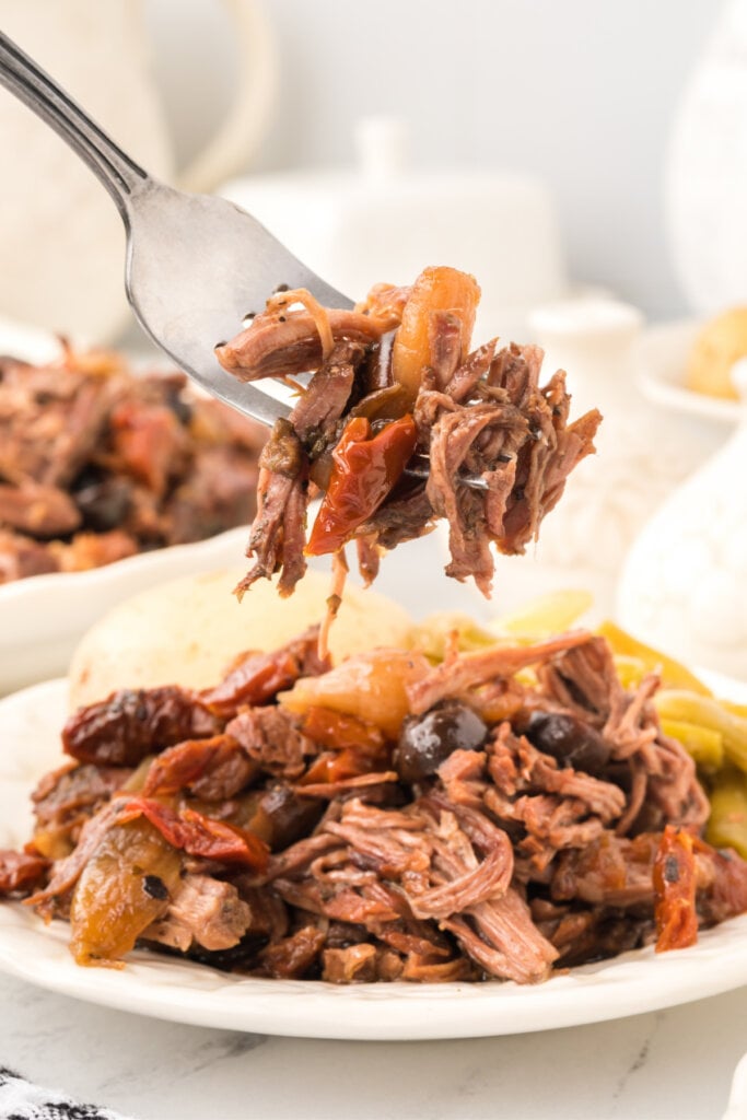 italian pot roast scooped off plate onto fork