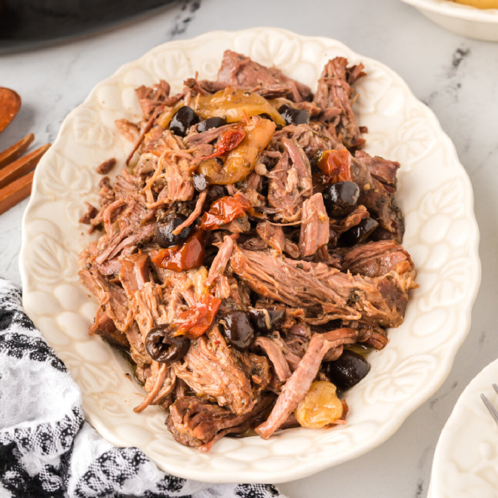 shredded slow cooker mediterranean pot roast on platter