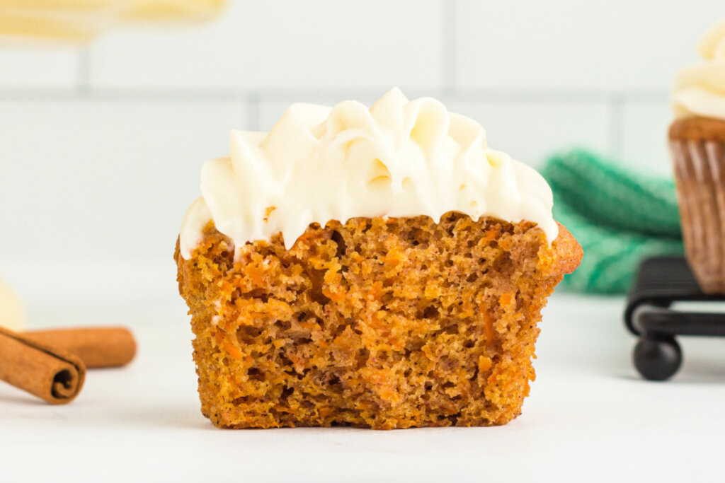 a cross-section of a carrot cake cupcake with cream cheese frosting