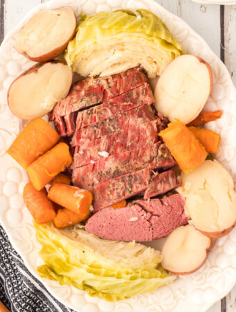 looking down onto a platter with corned beef, cabbage, potatoes, and carrots