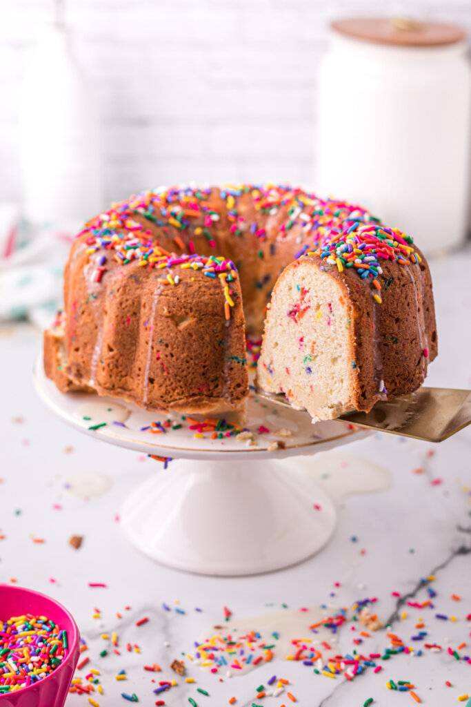 funfetti pound cake with slice missing on cake stand