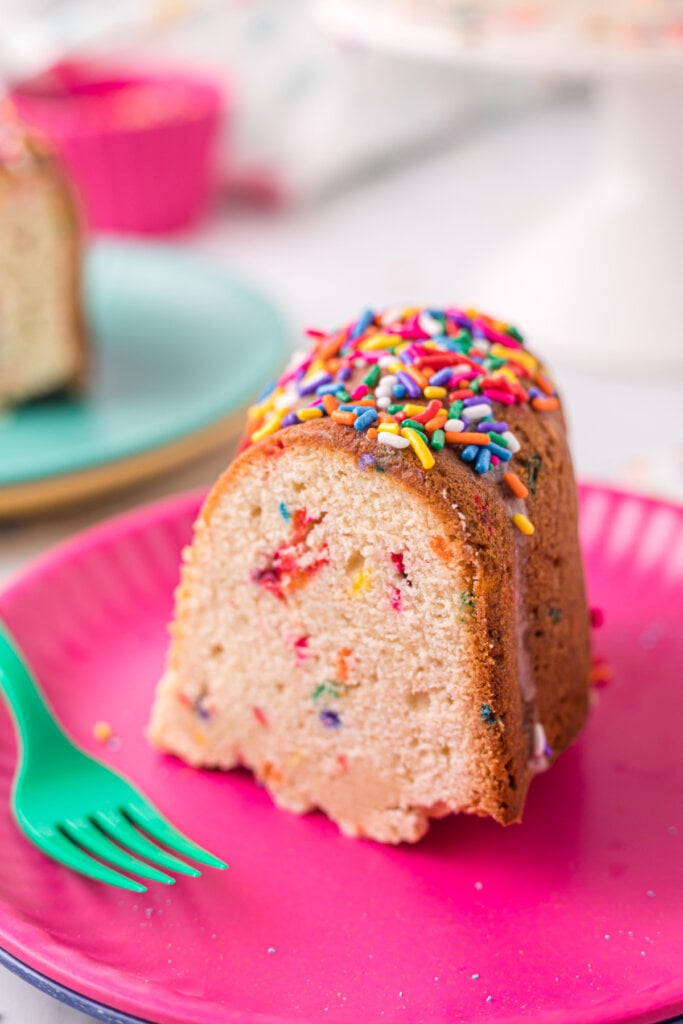 slice of funfetti pound cake on pink plate with teal fork