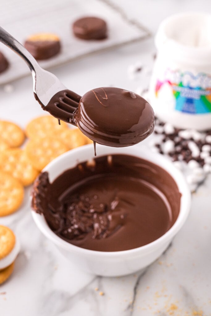 dipping cracker cookie in chocolate