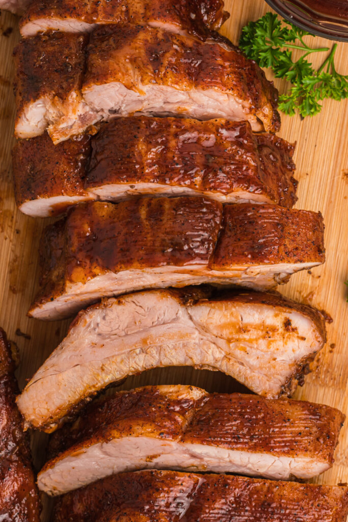 oven baked ribs cut into pieces on wooden cutting board