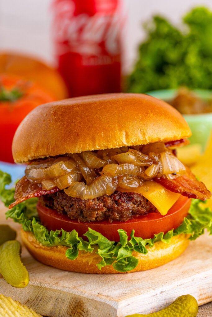 closeup of a bacon cheeseburger with coca cola onions