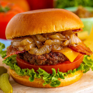 closeup of an assembled bacon cheeseburger with caramelized onions