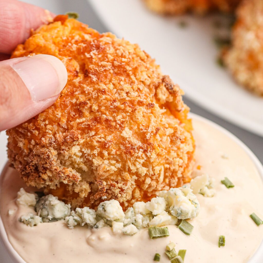buffalo chicken popper being dipped into blue cheese dip