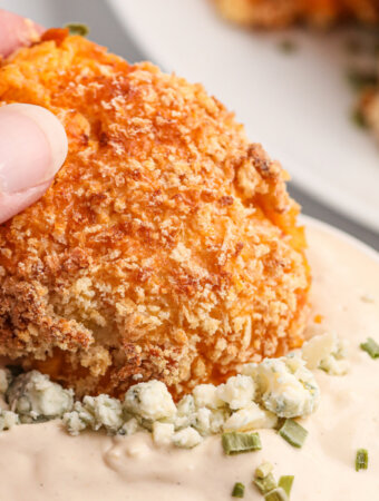 buffalo chicken popper being dipped into blue cheese dip