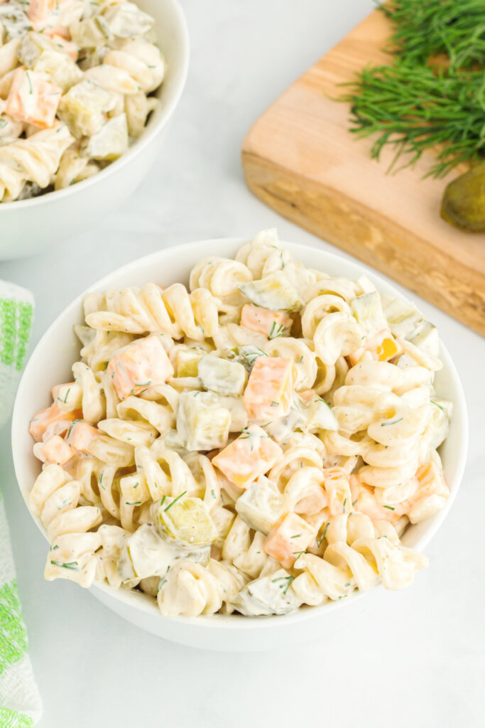 dill pickle pasta salad in white serving bowl