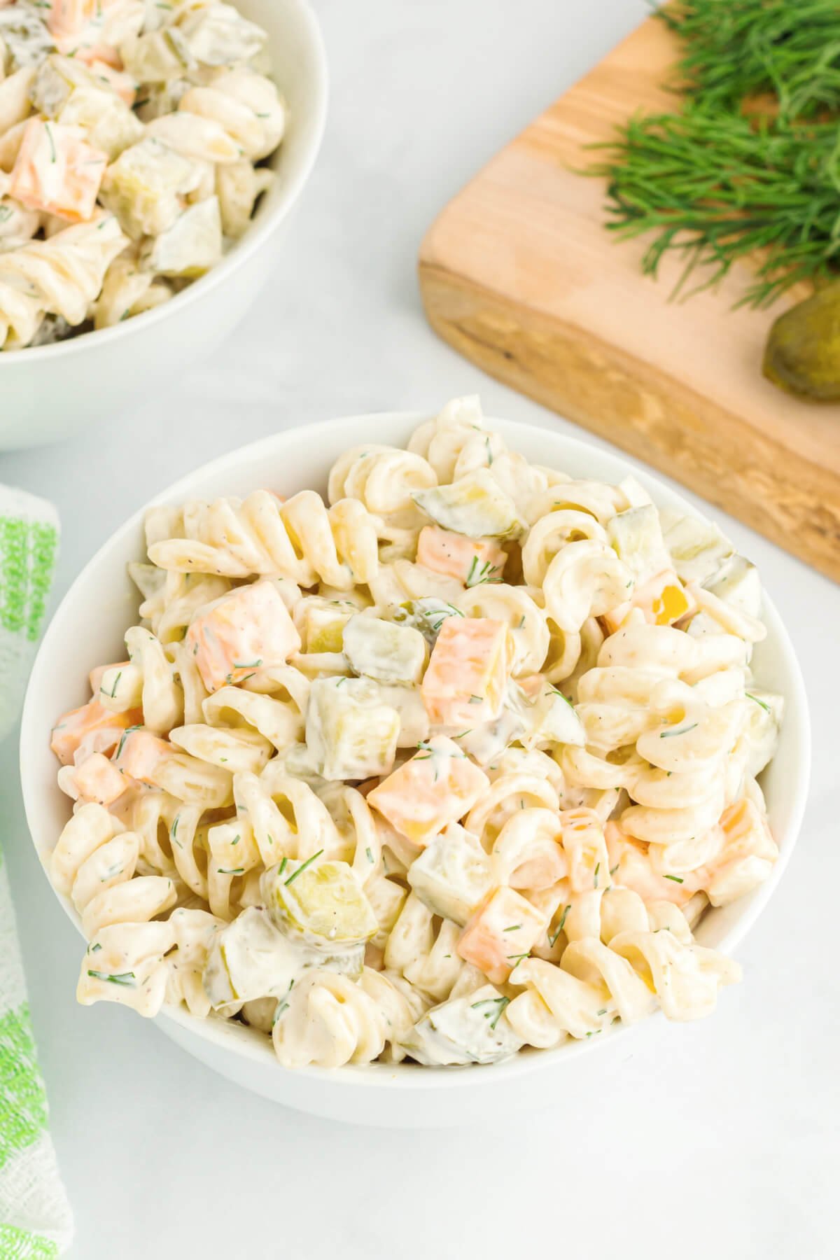 looking down onto a white bowl filled with dill pickle pasta salad