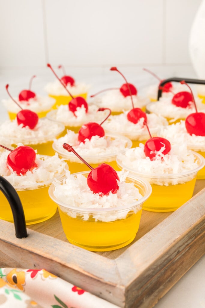 pina colada jello shots on a wooden serving tray