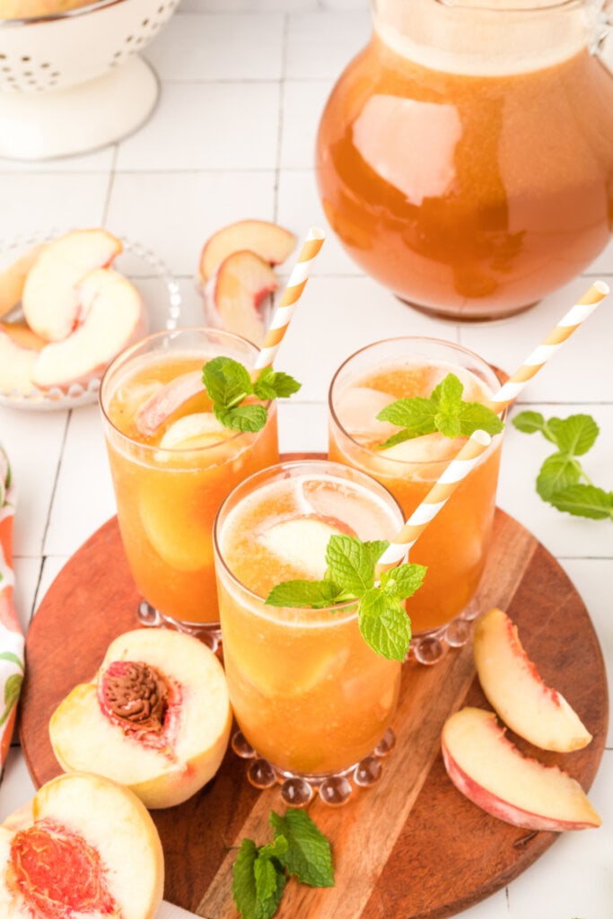 glasses of peach iced tea on wooden serving tray