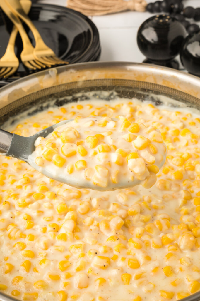 creamed corn scooped out of pan onto a serving spoon