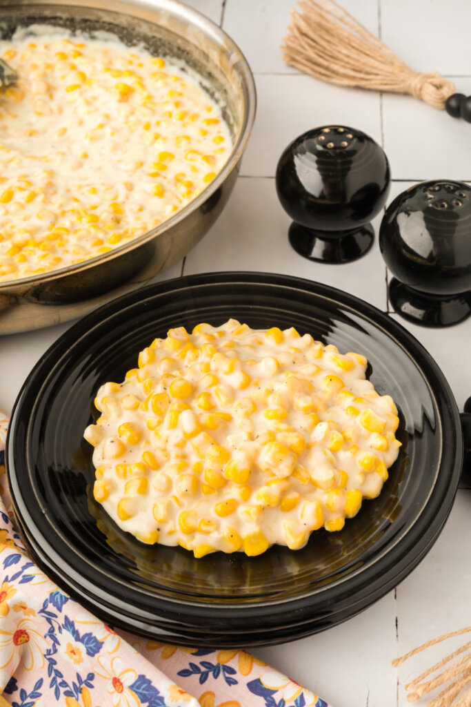 a serving of creamed corn on a black plate
