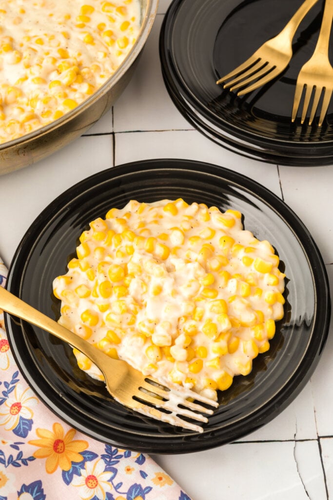 creamed corn on black plate with fork
