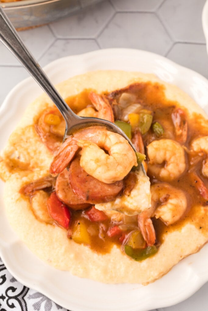 spoon scooping and holding shrimp and grits mixture