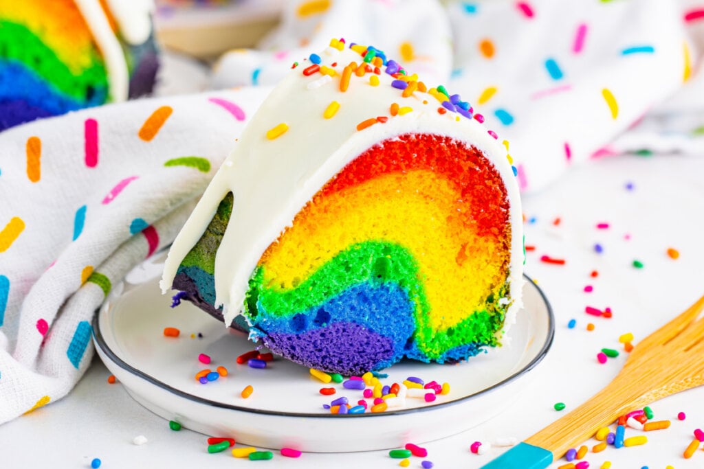 slice of rainbow cake on plate