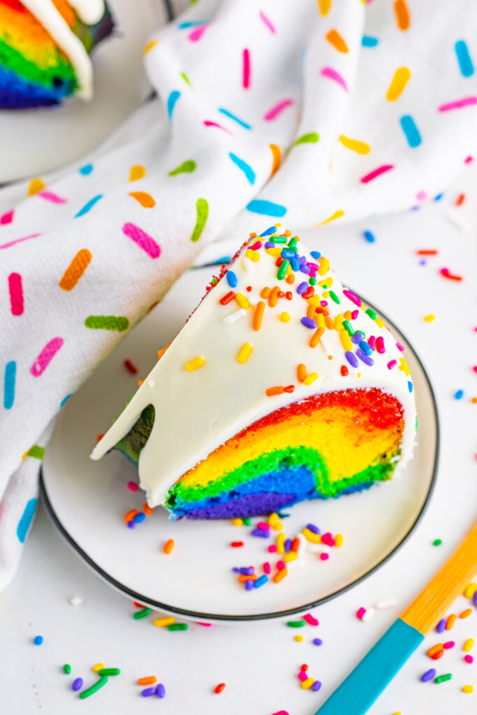 looking down onto a slice of rainbow cake on plate