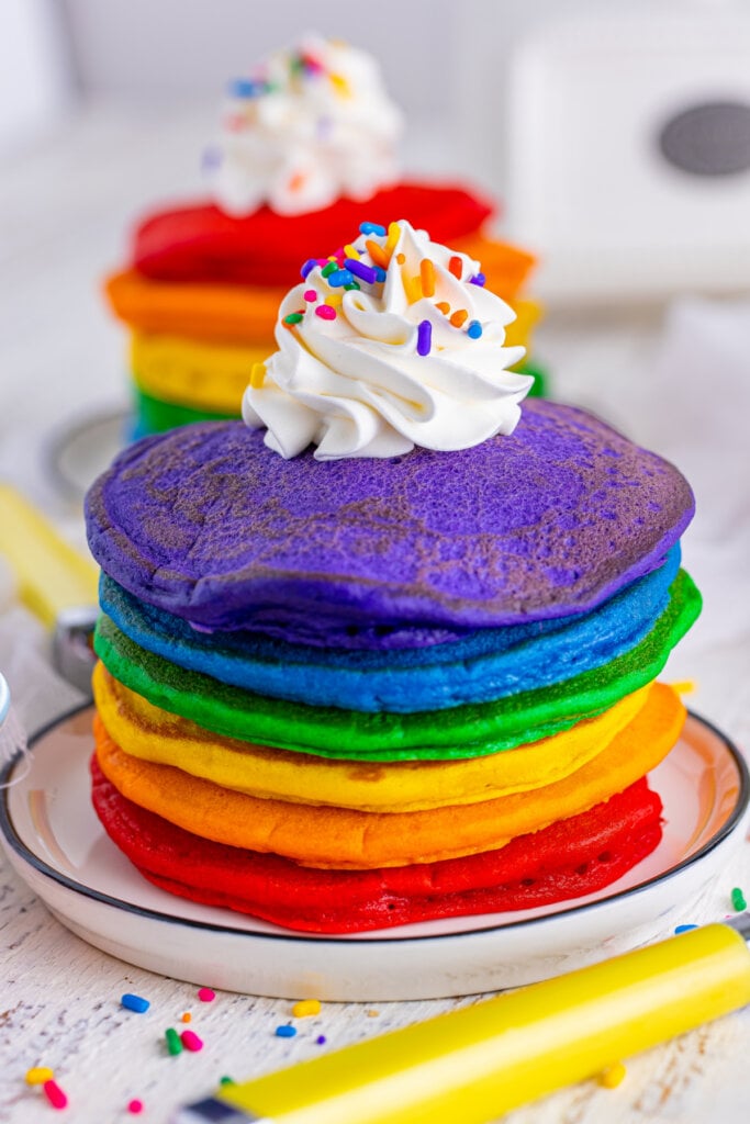 stack of rainbow pancakes on plate