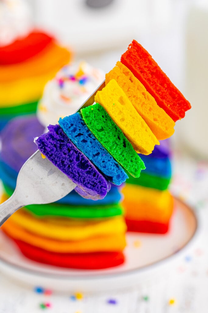 bite of rainbow pancakes with allof the colors on the fork