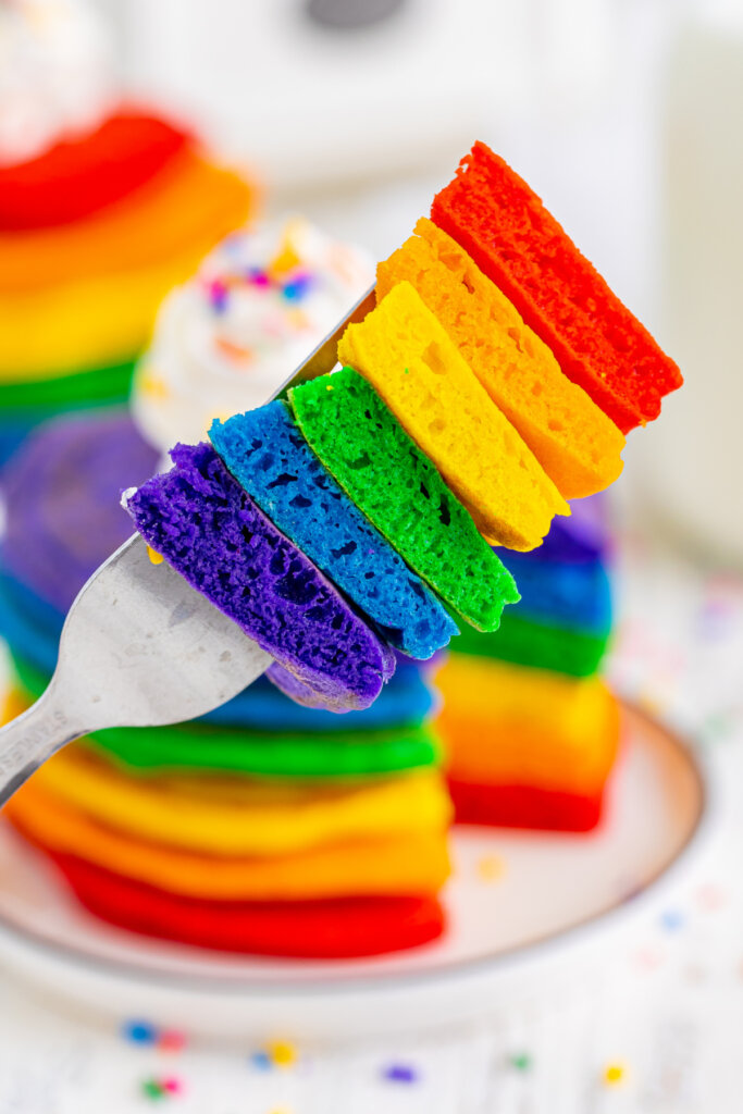 bite of rainbow pancakes with allof the colors on the fork