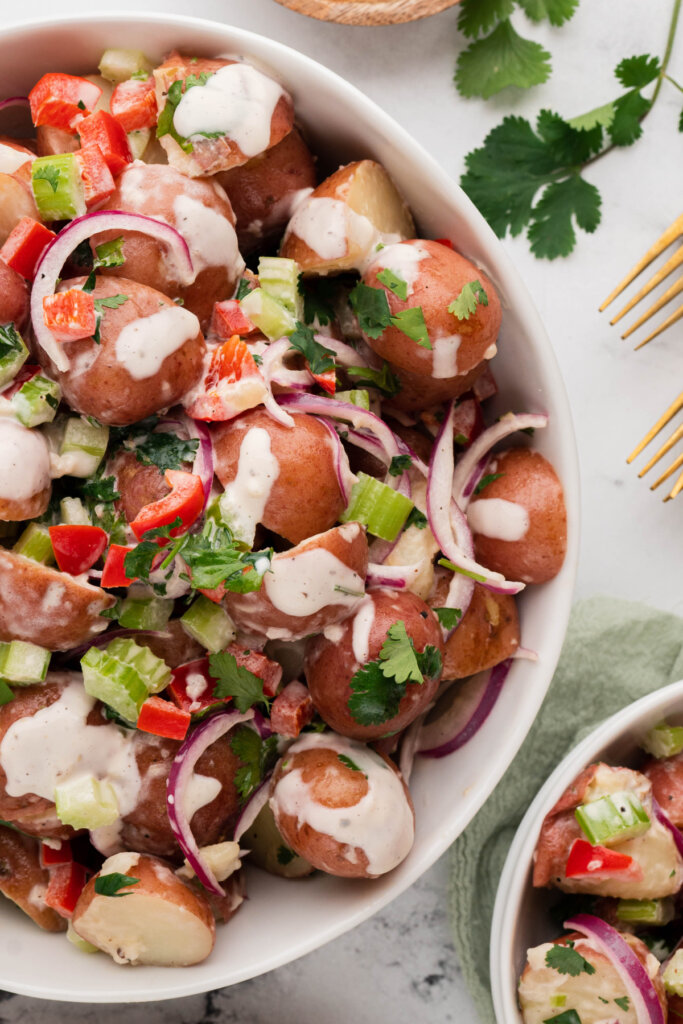 looking down onto a white bowl with red potato salad