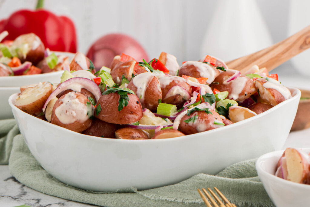 red skinned potato salad in white serving bowl