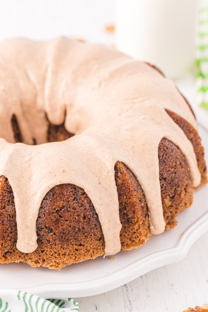 zucchini bundt cake with cinnamon icing on servng platter