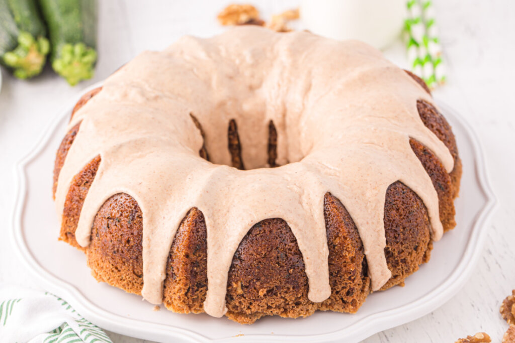 zucchini bundt cake with cinnamon icing on serving plate