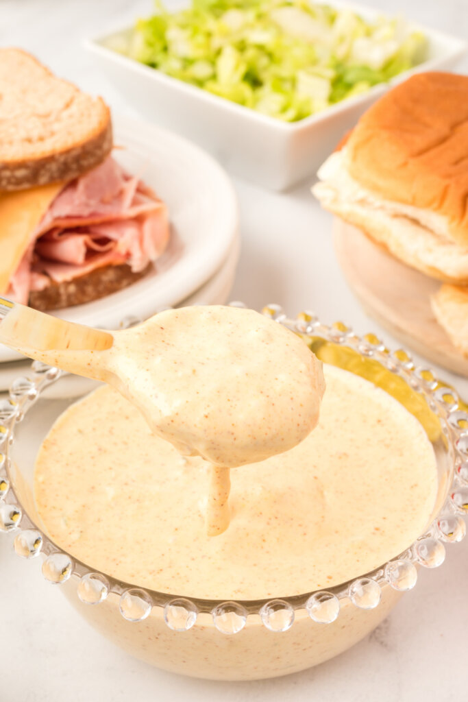 copycat big mac sauce pouring off a spoon into a bowl