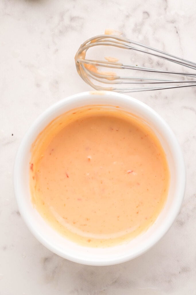 Homemade bang bang sauce whisked until smooth in a white bowl.