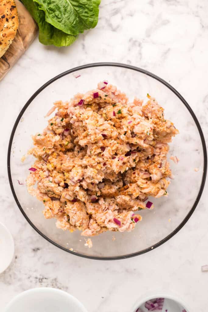 Seasoned ground chicken mixture mixed together for homemade chicken burgers.