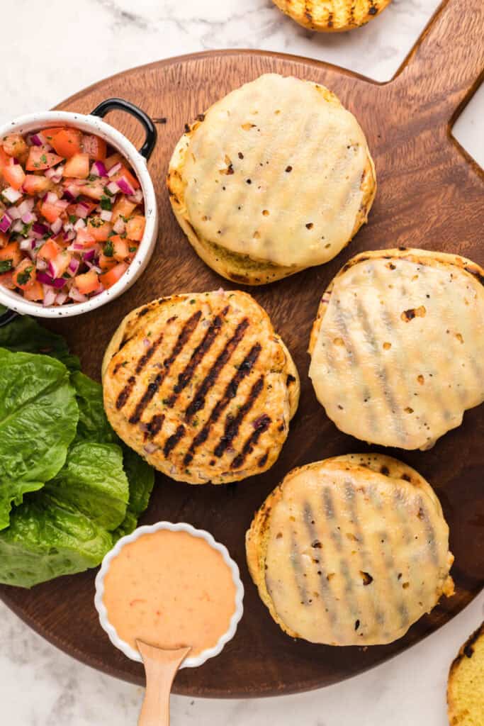 Grilled chicken burgers topped with melted Swiss cheese on toasted onion buns.