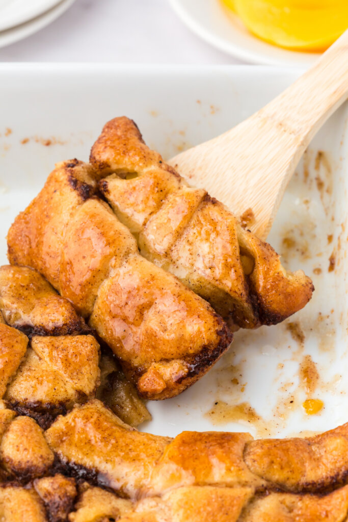 two peach crescent dumplings being scooped out of the pan