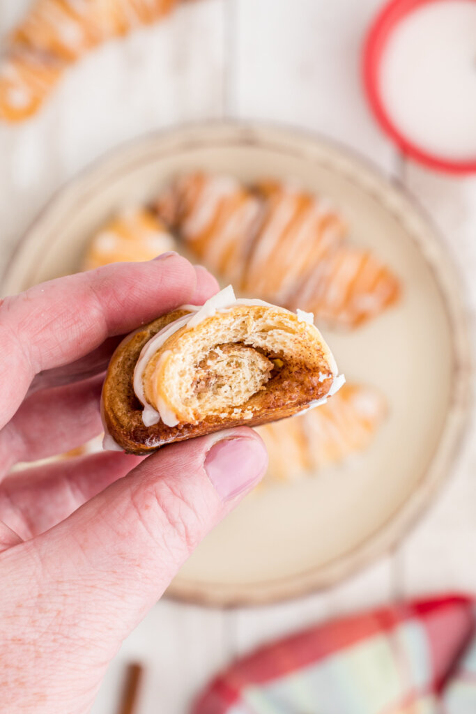 hand holding a cinnamn crescent roll showing the inside