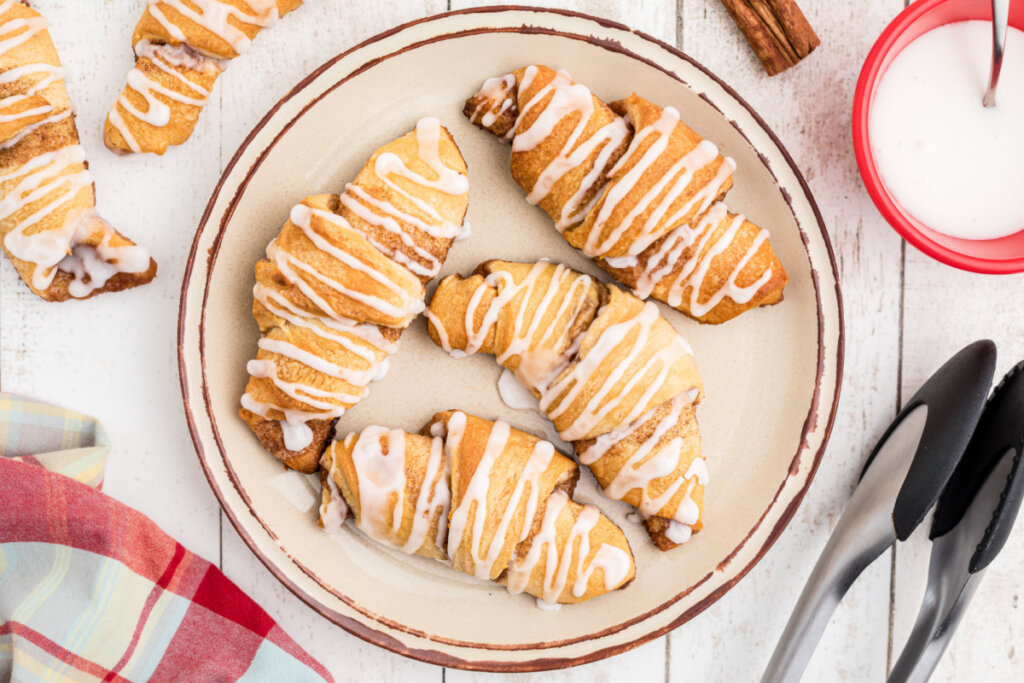 four cinnamon crescent rolls on a plate