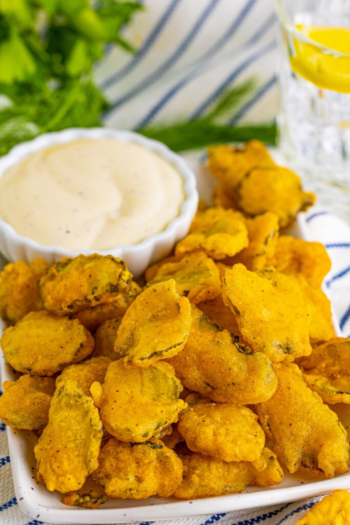 fried pickles with dipping sauce on serving platter
