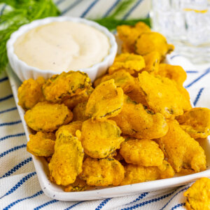 fried pickles with dipping sauce on serving platter