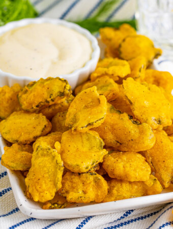 fried pickles with dipping sauce on serving platter