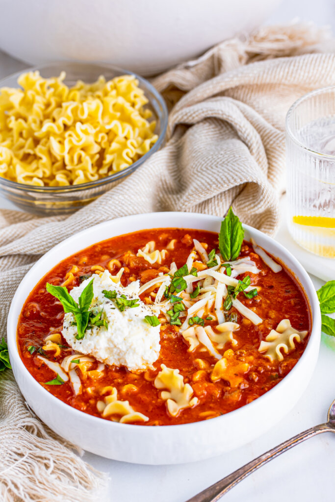 bowl of lasagna soup in foeground with bowl of noodles in back