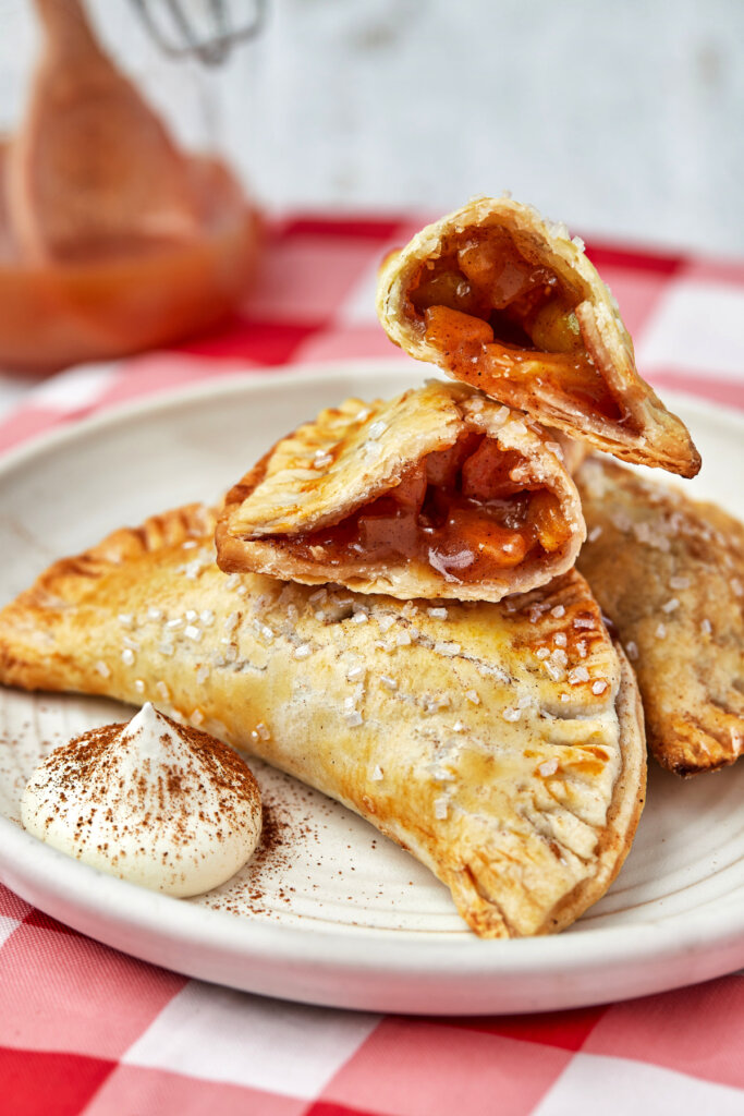 air fryer apple hand pies on plate with the top one opened to show the inside