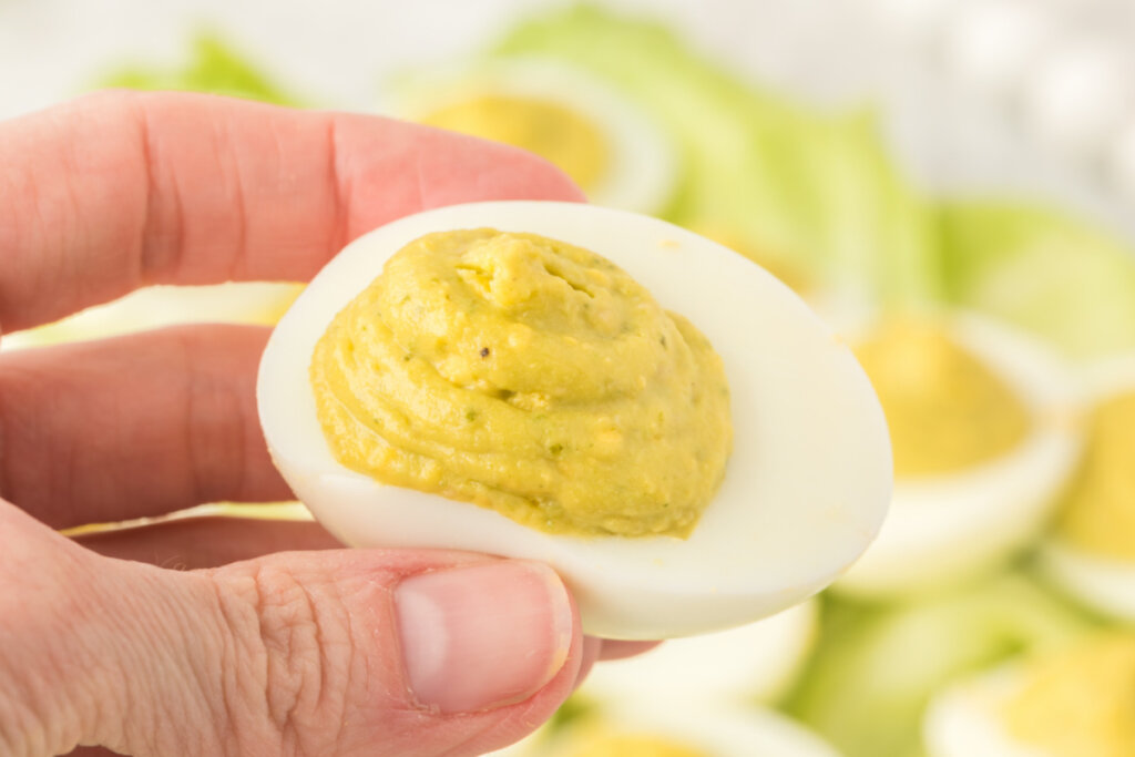 hand holding a finished deviled egg