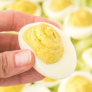 hand holding a pesto deviled egg