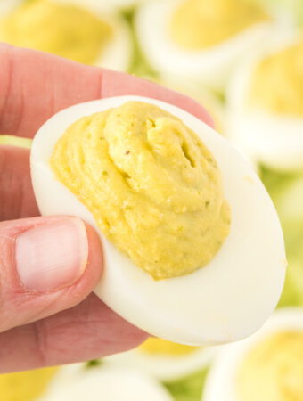 hand holding a pesto deviled egg